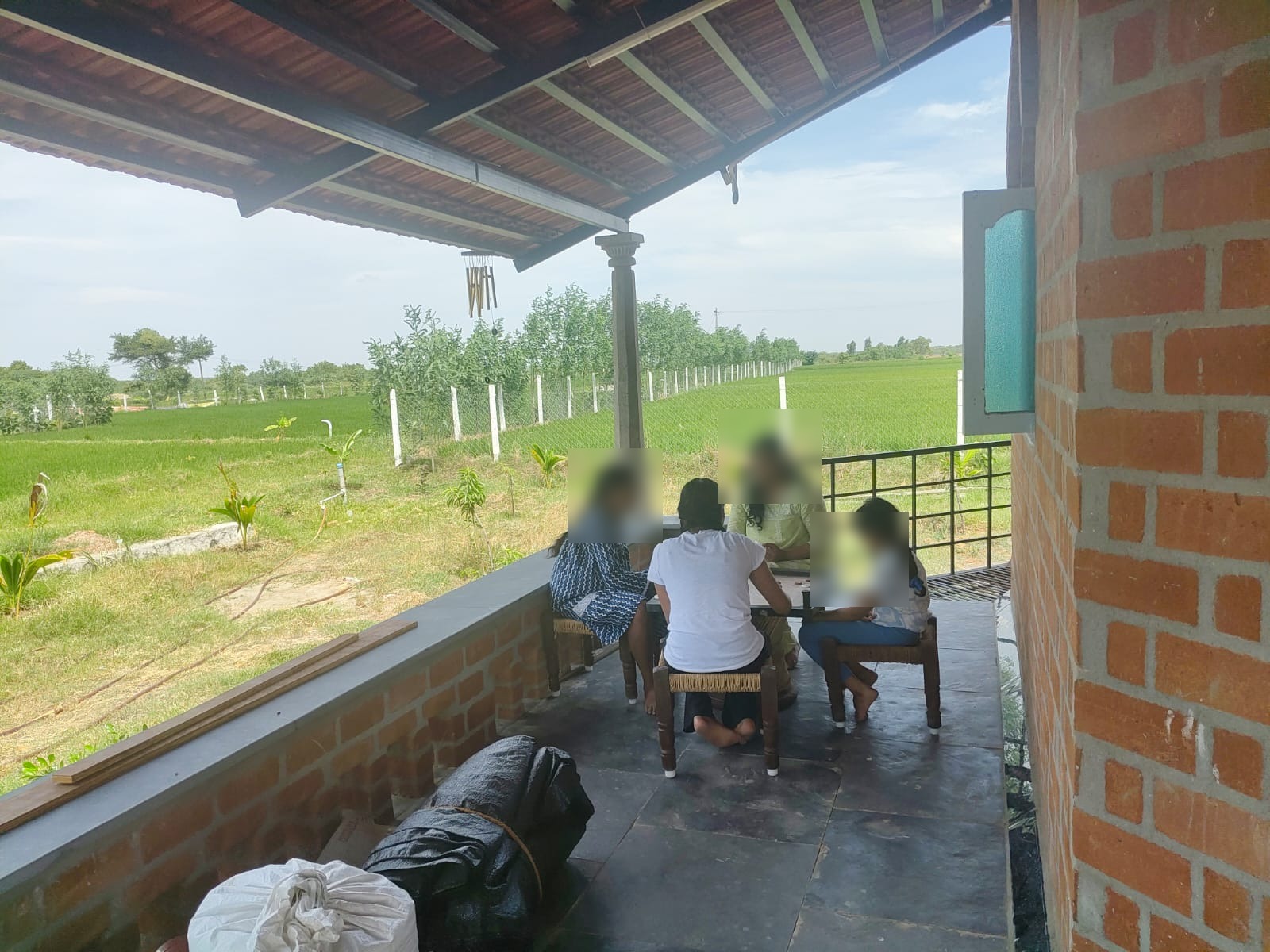 Family playing carrom on the farmhouse porch