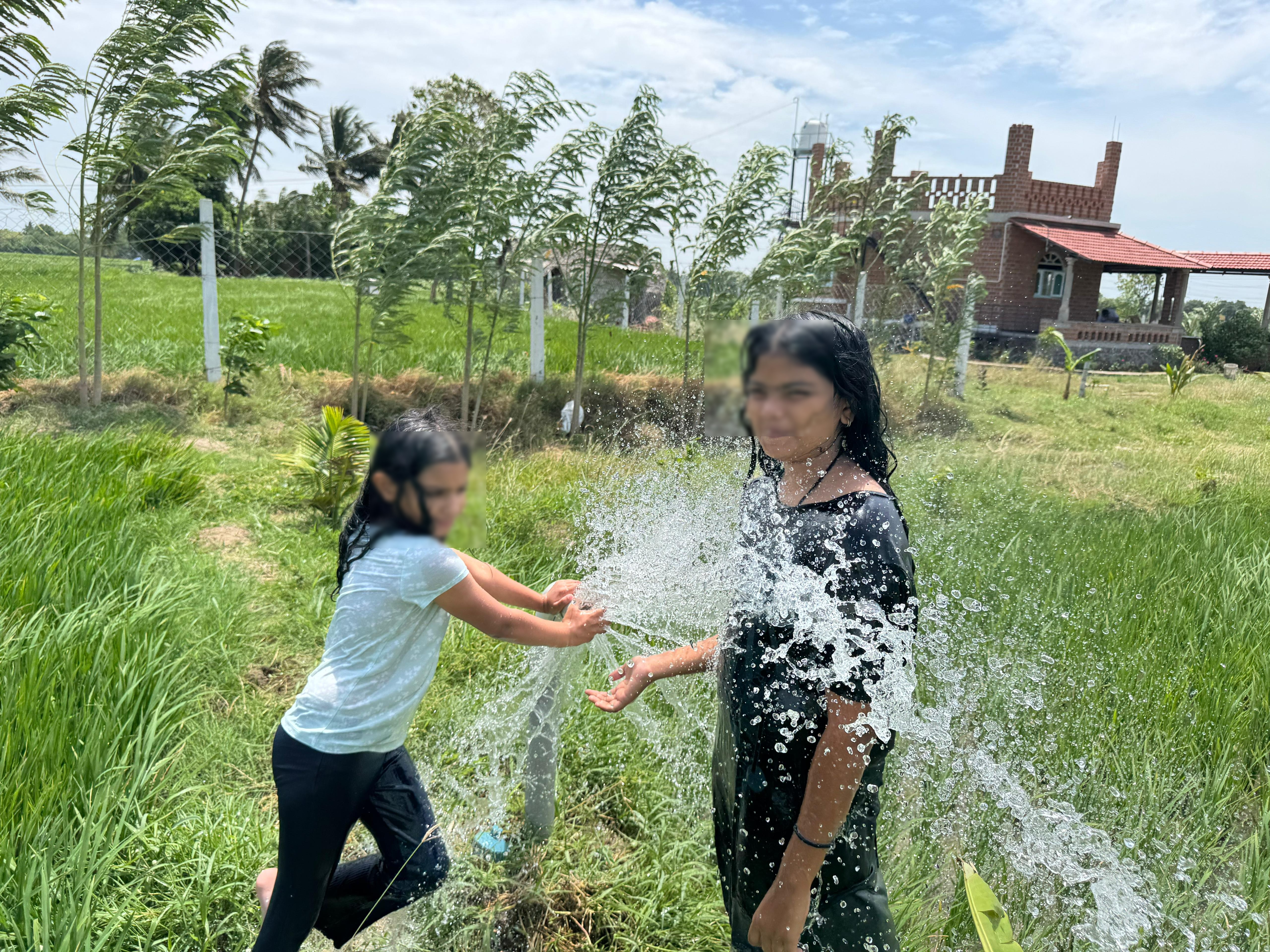 Kids playing with water in the farm fields